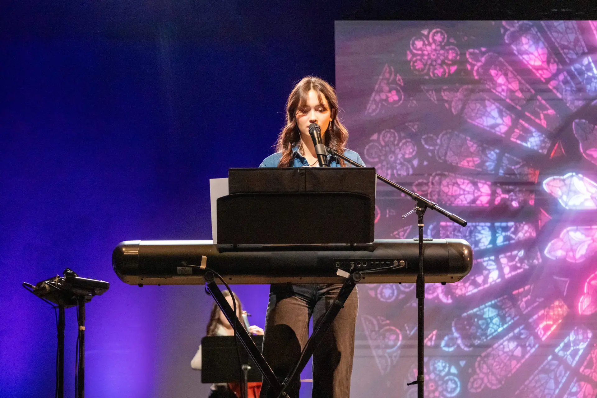 Woman singing and playing the keyboard at EagleNaz